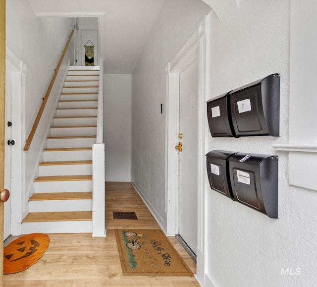 interior space with arched walkways, wood finished floors, and visible vents