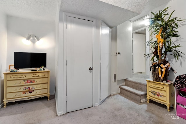 bedroom featuring visible vents, a closet, carpet flooring, and a textured ceiling