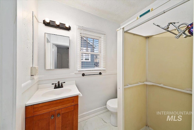 bathroom featuring baseboards, toilet, marble finish floor, a textured ceiling, and vanity