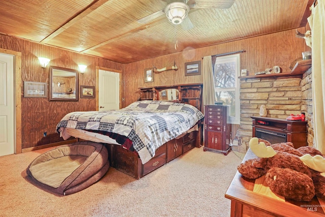 carpeted bedroom with ceiling fan, wood walls, and wood ceiling