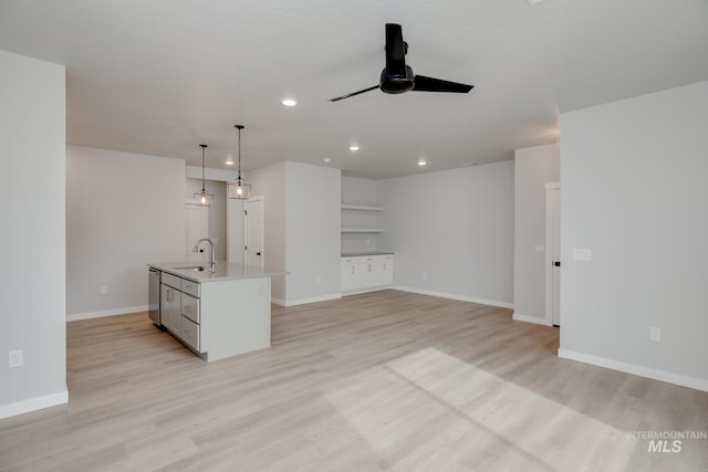 unfurnished living room featuring a ceiling fan, recessed lighting, baseboards, a sink, and light wood-type flooring