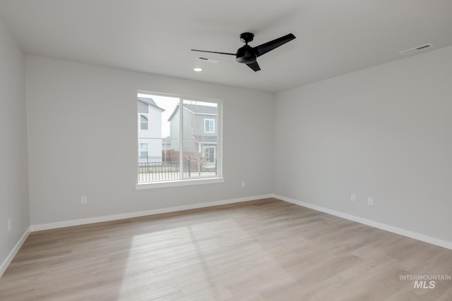 unfurnished room with ceiling fan, baseboards, visible vents, and light wood-style floors