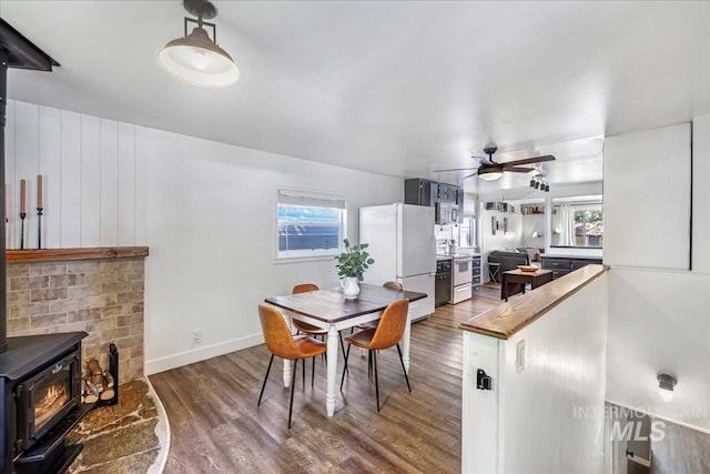 1984 11th Ave E, Twin Falls, ID 83301 - dining space with a wood stove, wood finished floors, a ceiling fan, and plenty of natural light