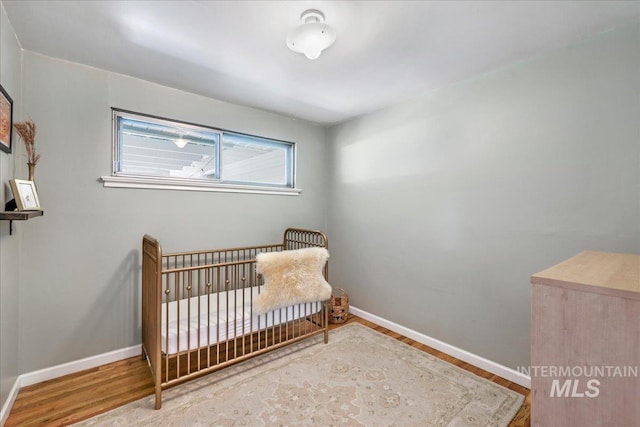 1984 11th Ave E, Twin Falls, ID 83301 - bedroom with wood finished floors, baseboards, and a crib