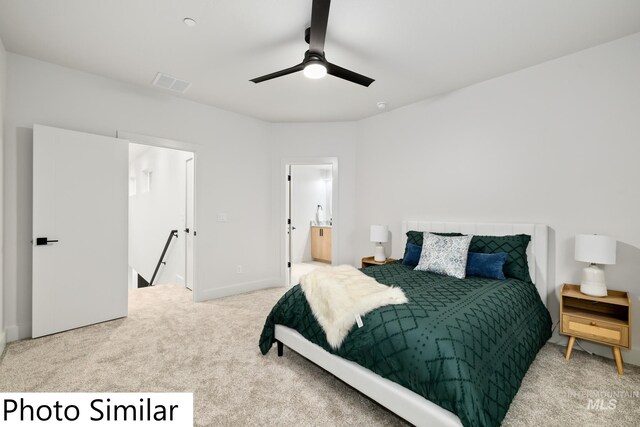 carpeted bedroom with visible vents, baseboards, ensuite bath, and a ceiling fan