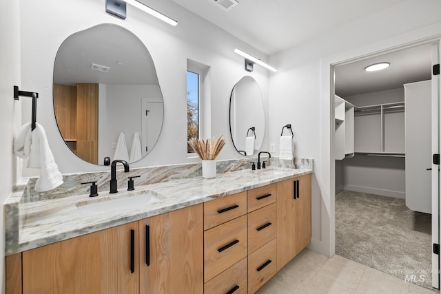 bathroom featuring double vanity, visible vents, tile patterned floors, and a sink