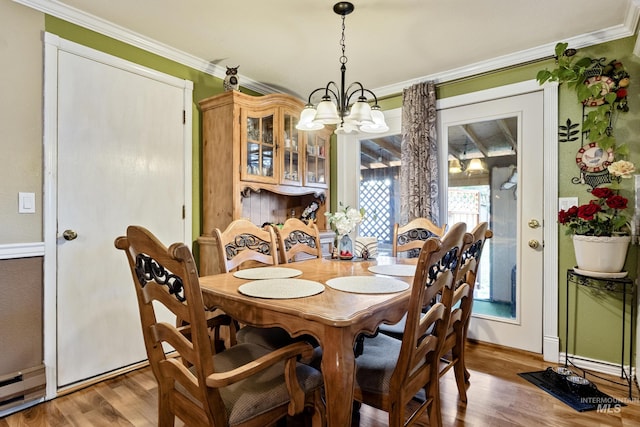 2819 Gemini, Caldwell, ID 83605 - dining room featuring a chandelier, wood finished floors, baseboards, and crown molding