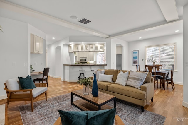 living room with beam ceiling and light wood-type flooring