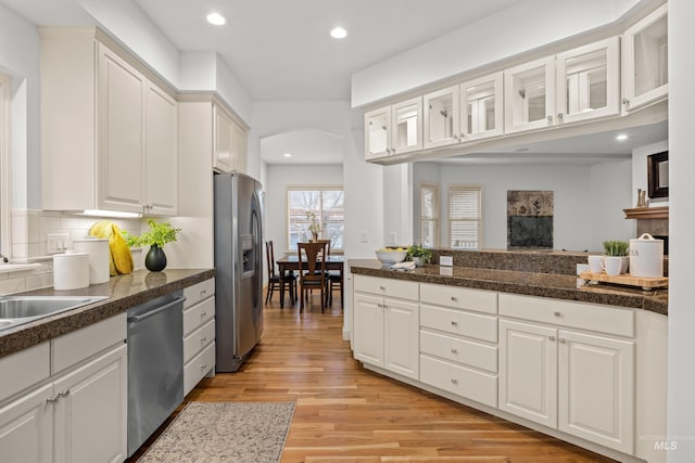 kitchen featuring tasteful backsplash, white cabinetry, sink, light hardwood / wood-style floors, and stainless steel appliances