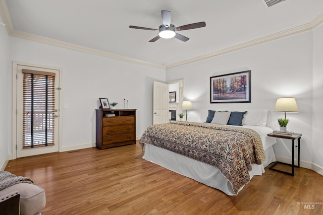 bedroom featuring crown molding, hardwood / wood-style floors, and access to exterior