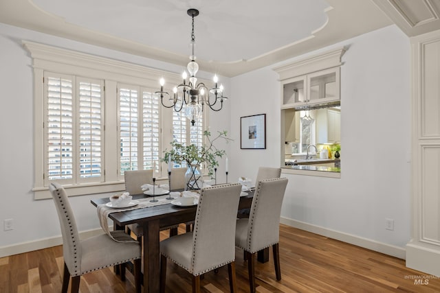 dining area with hardwood / wood-style flooring and a chandelier