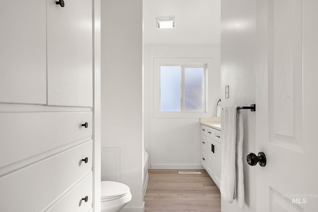 bathroom with vanity, hardwood / wood-style flooring, and toilet