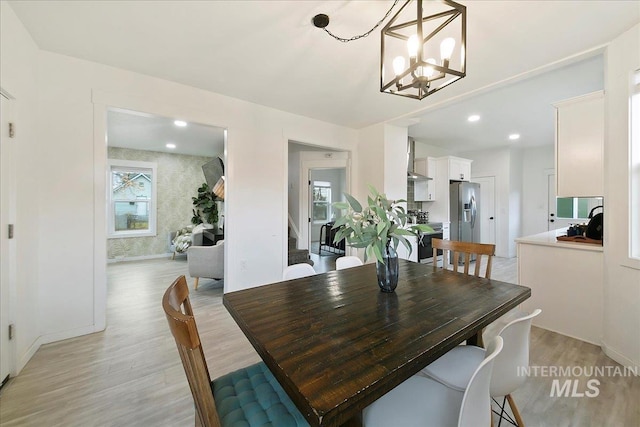 dining area with an inviting chandelier and light hardwood / wood-style flooring