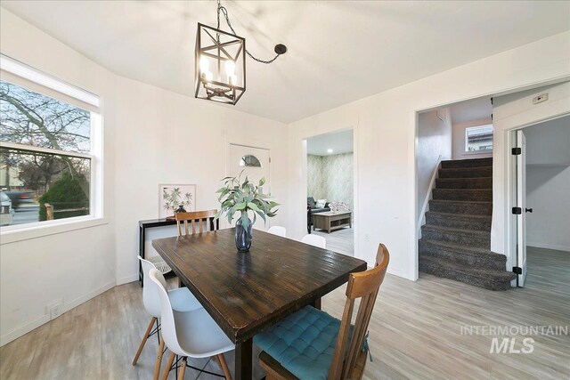 dining room with light wood-type flooring and a notable chandelier