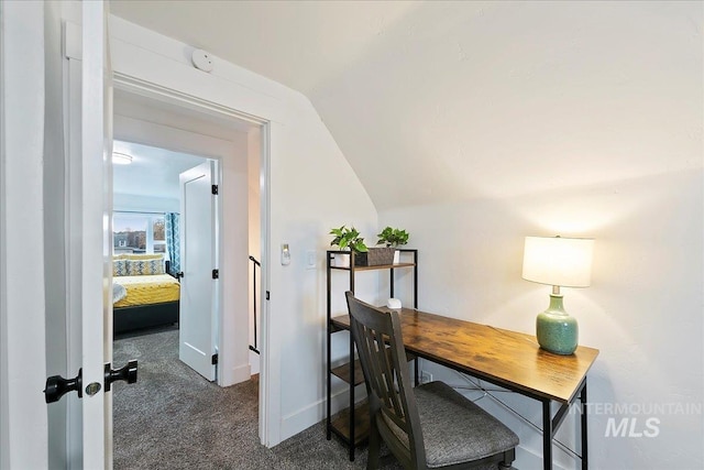 office space with dark carpet and vaulted ceiling