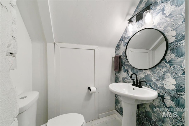 bathroom with tile patterned floors, lofted ceiling, and toilet