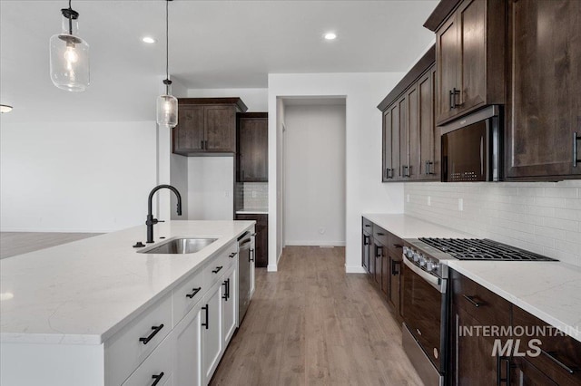 5278 W Mcnair St, Meridian, ID 83646 - kitchen with stainless steel gas range oven, a sink, dark brown cabinetry, tasteful backsplash, and white cabinets