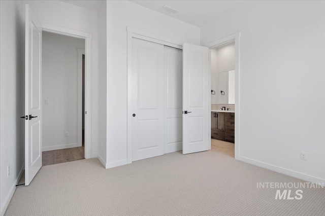 5278 W Mcnair St, Meridian, ID 83646 - unfurnished bedroom featuring light carpet, a closet, baseboards, and connected bathroom