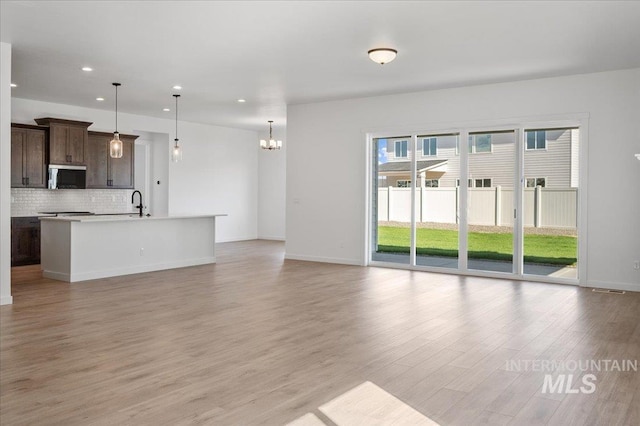 5278 W Mcnair St, Meridian, ID 83646 - unfurnished living room featuring recessed lighting, light wood-style flooring, a chandelier, baseboards, and a sink