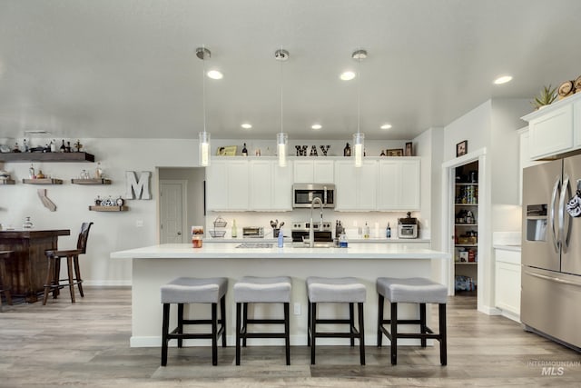 2982 W Mcintosh, Kuna, ID 83634 - kitchen featuring stainless steel appliances, light countertops, a center island with sink, a kitchen bar, and recessed lighting