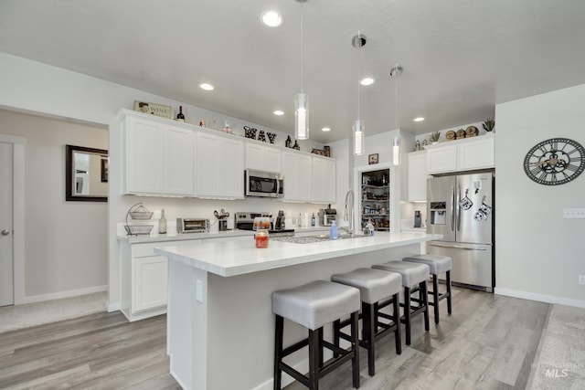 2982 W Mcintosh, Kuna, ID 83634 - kitchen featuring stainless steel appliances, light wood-style flooring, a kitchen breakfast bar, light countertops, and recessed lighting