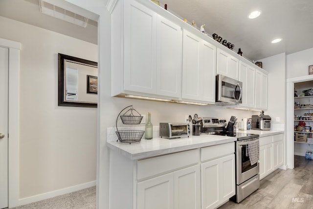 2982 W Mcintosh, Kuna, ID 83634 - kitchen with stainless steel appliances, light countertops, white cabinets, recessed lighting, and baseboards