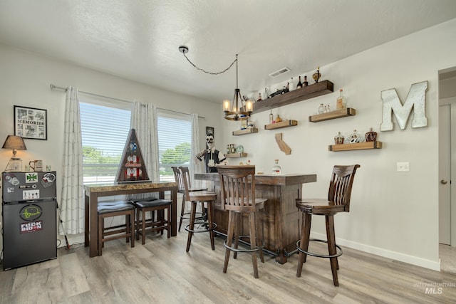 2982 W Mcintosh, Kuna, ID 83634 - indoor dry bar featuring wood finished floors, a chandelier, and baseboards