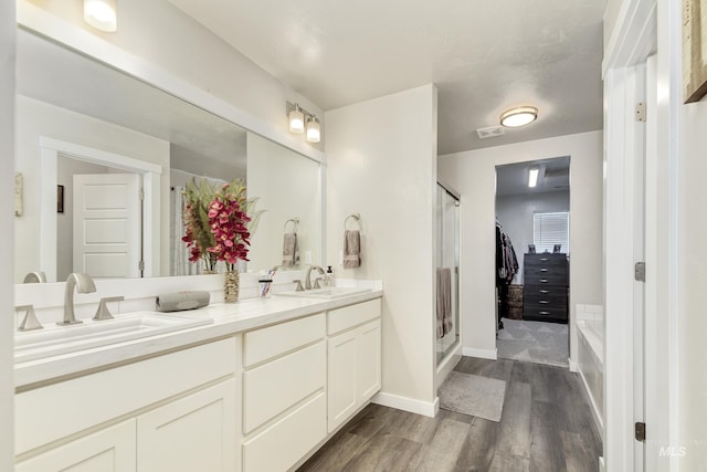 2982 W Mcintosh, Kuna, ID 83634 - full bathroom featuring wood finished floors, a shower stall, double vanity, baseboards, and a bath