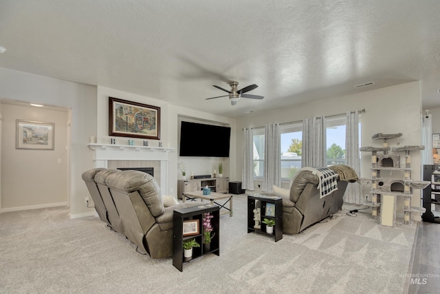 2982 W Mcintosh, Kuna, ID 83634 - living room featuring ceiling fan, a tile fireplace, baseboards, carpet floors, and a textured ceiling
