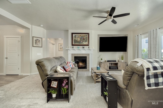 2982 W Mcintosh, Kuna, ID 83634 - living area with ceiling fan, a tiled fireplace, carpet floors, and baseboards