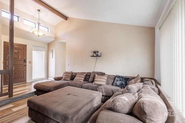 living area featuring high vaulted ceiling, wood finished floors, and beam ceiling