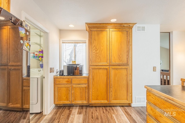 kitchen featuring light wood-style floors, washer / clothes dryer, and visible vents