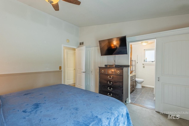 carpeted bedroom with lofted ceiling, visible vents, ceiling fan, and ensuite bathroom