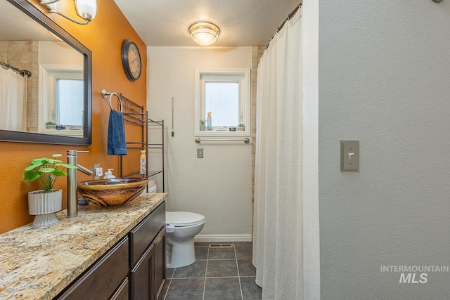 bathroom with baseboards, toilet, a shower with curtain, tile patterned floors, and vanity