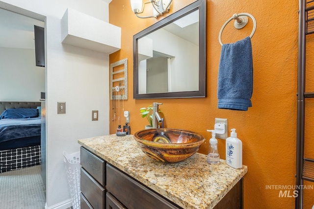 ensuite bathroom with connected bathroom and vanity