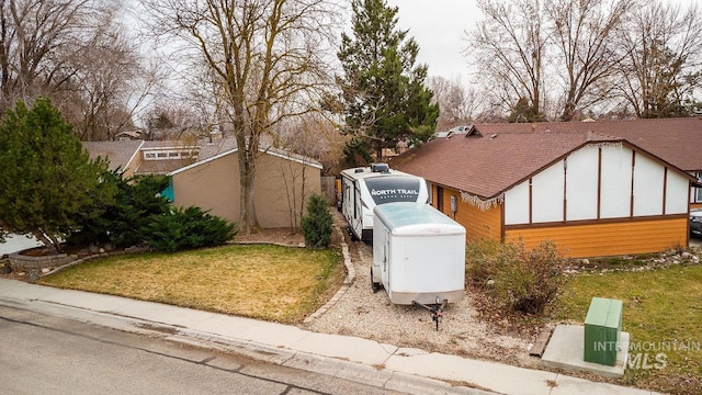 view of side of property featuring roof with shingles and a lawn