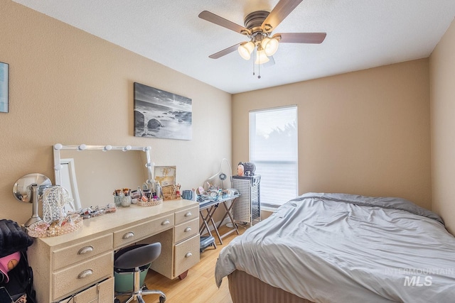 bedroom with a ceiling fan and light wood-style flooring