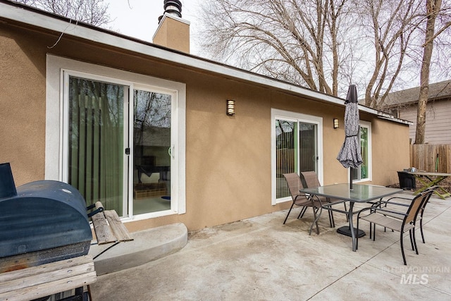 view of patio with outdoor dining space and fence