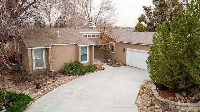 view of front of house with an attached garage, driveway, a shingled roof, and stucco siding