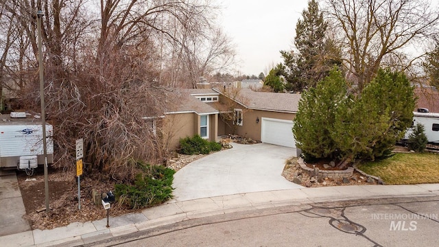 view of front of house with driveway, a garage, and stucco siding