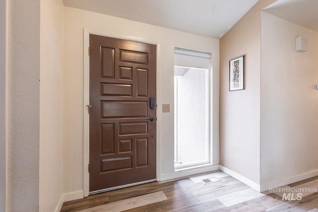 foyer entrance with light wood-type flooring and baseboards