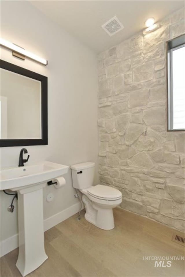 bathroom with hardwood / wood-style floors and toilet