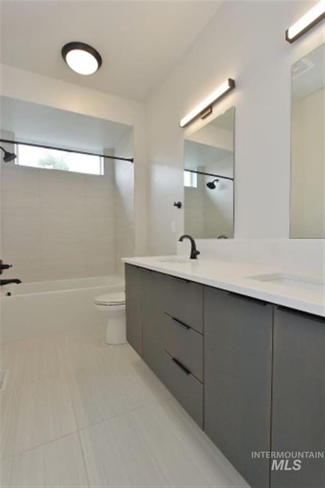 full bathroom with tiled shower / bath combo, tile patterned flooring, vanity, and toilet