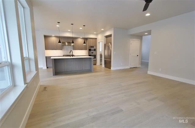 interior space with light hardwood / wood-style floors, ceiling fan, and sink