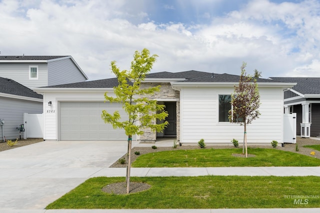 view of front of home with a garage, driveway, and a front lawn