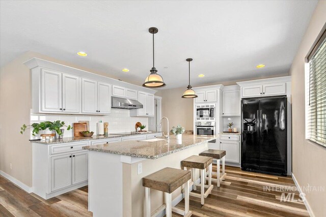8618 Latimore Ln, Middleton, ID 83644 - kitchen featuring black appliances, a sink, decorative backsplash, wood finished floors, and white cabinets