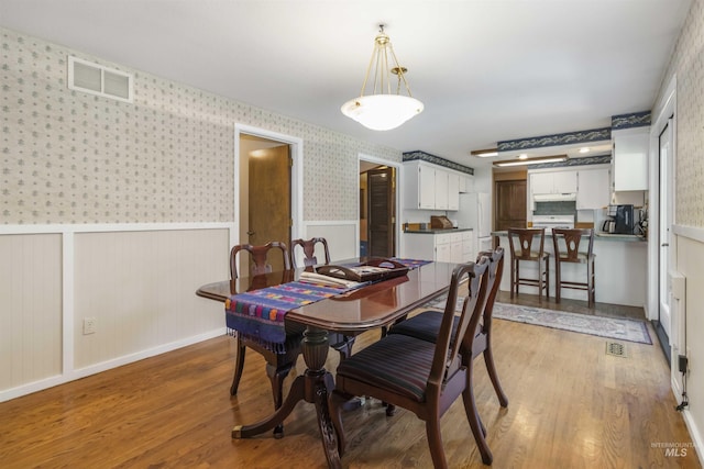 1719 S Gekeler Ln, Boise, ID 83706 - dining area featuring wainscoting, wood finished floors, and wallpapered walls