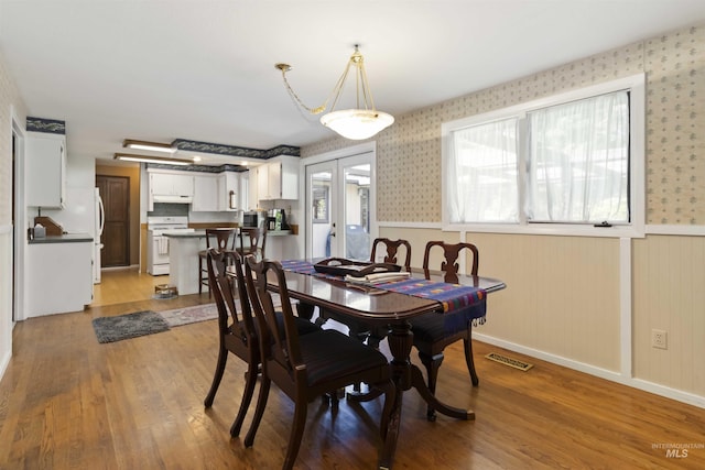 1719 S Gekeler Ln, Boise, ID 83706 - dining room with wallpapered walls, light wood finished floors, and wainscoting