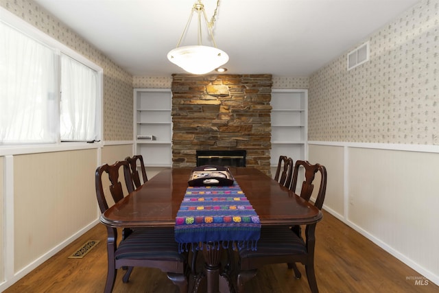 1719 S Gekeler Ln, Boise, ID 83706 - dining space featuring wallpapered walls, a wainscoted wall, wood finished floors, a stone fireplace, and baseboards