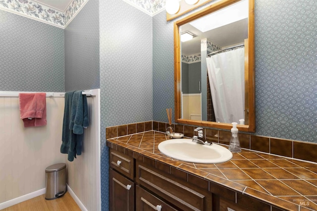 1719 S Gekeler Ln, Boise, ID 83706 - full bathroom with vanity, wood finished floors, and wallpapered walls
